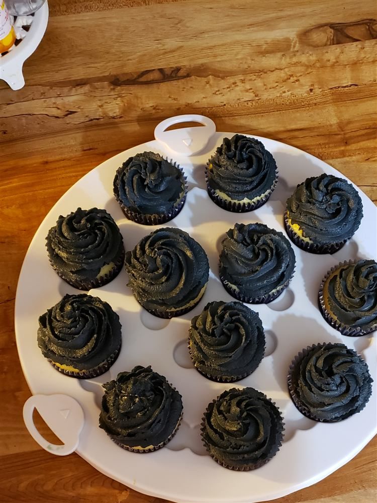 Black swirl cupcakes on a white stand