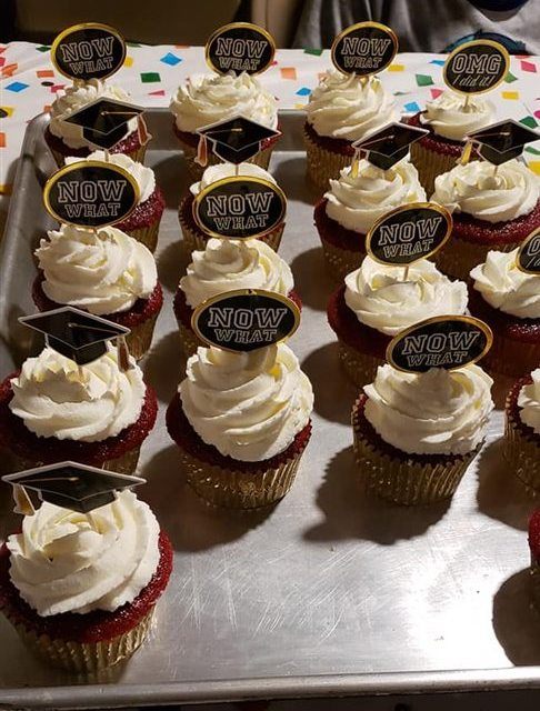 A display of cupcakes with celebration toppers